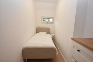 a small bed in a small room with a window at Turawski Zakątek in Turawa