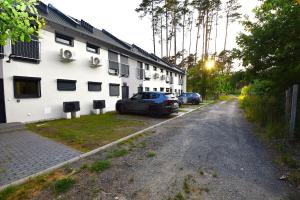 a car parked in front of a white building at Turawski Zakątek in Turawa