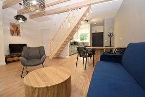 a living room with a blue couch and a table at Turawski Zakątek in Turawa