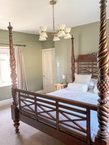 a bedroom with a large bed with a wooden frame at Castle Cottage Winchcombe in Winchcombe