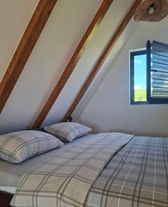 a bedroom with two beds in a attic at Ninina koliba-vikendica Manjaca in Hiseti