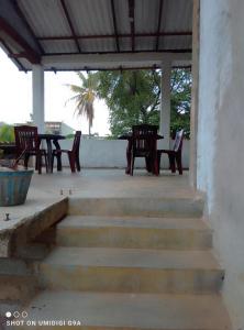 a patio with tables and chairs and a table at Rithu Homestay in Sigiriya