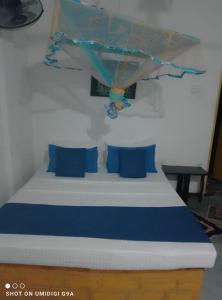 a bed with blue pillows in a room at Rithu Homestay in Sigiriya