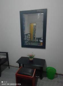 a mirror on a wall with a table and a mirror at Rithu Homestay in Sigiriya +2 photos