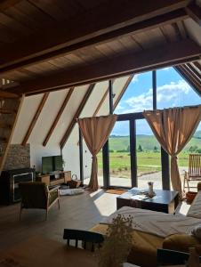 a living room with a large window with a view at Ninina koliba-vikendica Manjaca in Hiseti