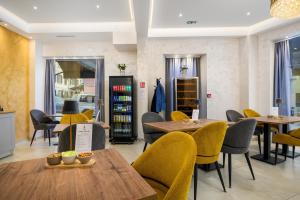 a restaurant with wooden tables and yellow chairs at Boutique Hotel Golden Key - Poreč - Bed & Breakfast in Poreč