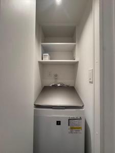 a small refrigerator in a small kitchen with a sink at MARUKOUHOTEL 入船 inn in Tokyo