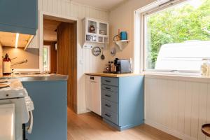 a kitchen with blue cabinets and a window at Reineblikk in Moskenes
