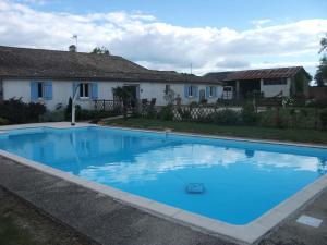 a large blue swimming pool in front of a house at les bleuet in Cours