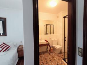 a bathroom with a bed and a sink and a toilet at Concha de Moledo in Moledo
