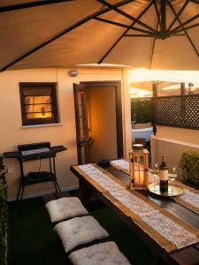 an outdoor patio with a table and a picnic table at Old Town Rhapsody, Cosy 2-Floor Home with Rooftop Bathtub, BBQ & Lounge Under Sun Umbrellas in Rethymno