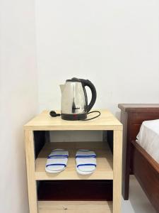 a tea kettle on a table next to a bed at Homestay Anugerah Tumpak sewu in Lumajang