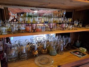 a bunch of glasses on a shelf at Карагьозовата Къща - цяла къща - 6 големи спални, 6 бани и отделна механа in Koprivshtitsa
