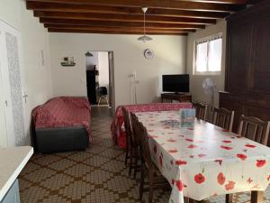 a living room with a table and a bedroom at Au lic in Montsoué