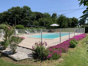 a tennis court in a garden with purple flowers at Au lic in Montsoué