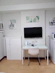 a white desk with a television and a white chair at Compact Studio Unit l Mesaverte Residences 8th Floor in Pontud