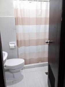 a bathroom with a toilet and a shower curtain at Compact Studio Unit l Mesaverte Residences 8th Floor in Pontud