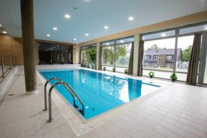 a large swimming pool in a building with a large window at Luxusní apartmán Perla in Říčky