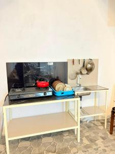 a kitchen with a table with dishes and utensils at Homestay Anugerah Tumpak sewu in Lumajang