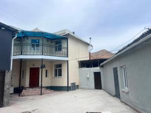 a building with a balcony on top of it at Terme Guesthouse in Naryn