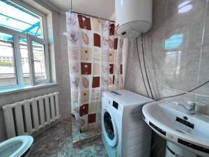 a bathroom with a washing machine and a sink at Terme Guesthouse in Naryn