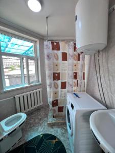a bathroom with a sink and a washing machine at Terme Guesthouse in Naryn