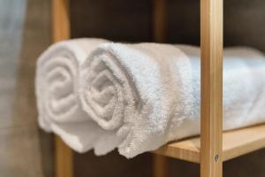 a pile of white towels on a shelf at Foresteria BB Sul Lago in Porlezza +28 photos