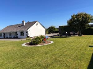 a house with a yard with green grass at Fiona's Country Accommodation in Murphyʼs Bridge