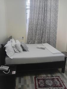 a bed sitting in a room with a window at Nelca Executive Lodge in Mwanza