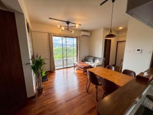a living room with a table and a couch at CondoYumangi in Onna