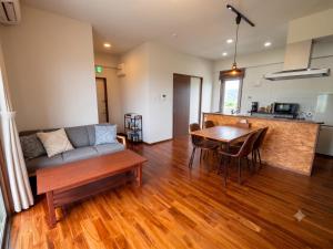 a living room with a couch and a table at CondoYumangi in Onna