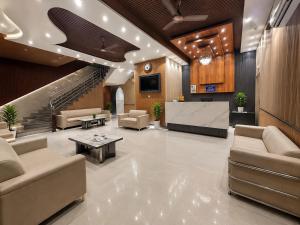 a lobby with couches and a table and stairs at Hotel The Luxury Delhi Airport in New Delhi