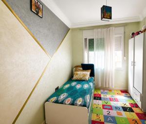 a small room with a bed and a chair at Stylish and valm appartement in Kenitra
