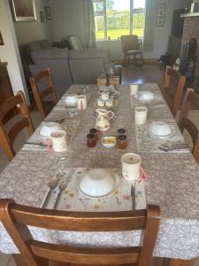 a dining room table with plates and dishes on it at Fiona's Country Accommodation in Murphyʼs Bridge +25 photos