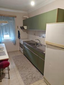 a kitchen with green cabinets and a sink at Harys Home in Korinos