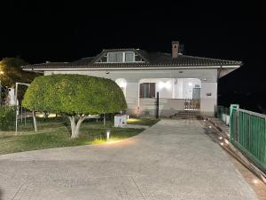 a white house with a tree in front of it at Villa Lidia & Attico degli artisti, free pets , giardino recintato e attrezzato in Minturno