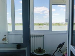 a room with three windows with a view of the water at Apartament Pelicanul in Tulcea