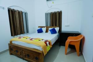 a bedroom with a bed and a chair in it at Nirmalyam Homestay in Kuttippuram