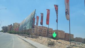 a building with flags on the side of a road at Luxury Studio in 6october in 6th Of October