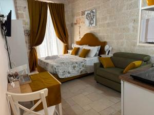 a bedroom with a bed and a couch and a table at Casa Nave in Monopoli