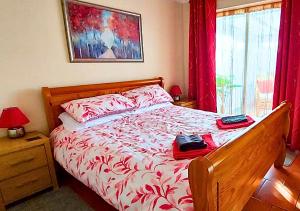 a bedroom with a bed with red and white sheets at The Perfect Beach Getaway for Couples in Sutton on Sea