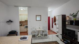 a living room with a table and a kitchen at Koviljača park in Banja Koviljača