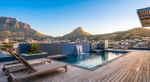 a deck with a pool with mountains in the background at Cape Royale Luxury Suite 602 in Cape Town