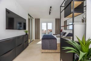 a living room with a kitchen with a couch and a tv at Korina Suites - 2 appartments, 1 with jacuzzy in Dramalj