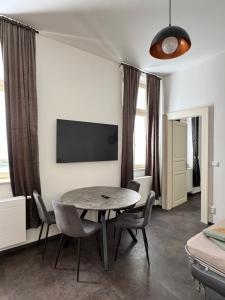 a dining room with a table and chairs and a tv at Perlová Suites in Pilsen