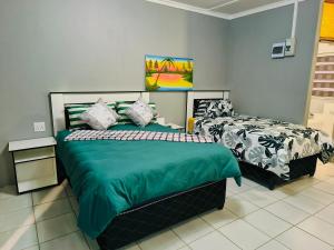 a bedroom with two beds with green sheets at Ave Maria Camping site in Welkom