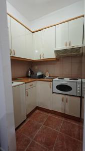 a kitchen with white cabinets and a stove at Koviljača park in Banja Koviljača