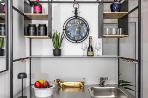 a kitchen with a sink and a clock on the wall at Korina Suites - 2 appartments, 1 with jacuzzy in Dramalj +117 photos