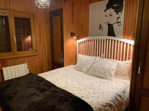 a bedroom with a bed and a picture of a woman at Comfortable Chalet with spectacular mountain views in Verchaix