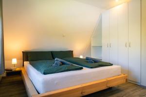 a bedroom with a large bed with white cabinets at Reetdachhaus Laurin in Dranske in Dranske